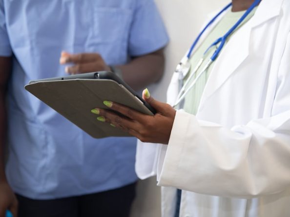 Doctor showing patient information on tablet in clinic