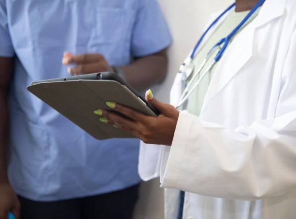 Doctor showing patient information on tablet in clinic